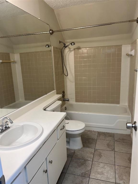 full bathroom featuring tile patterned floors, vanity, a textured ceiling, and shower / bathtub combination