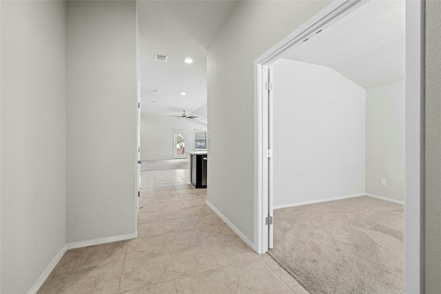 corridor with light tile patterned flooring and lofted ceiling