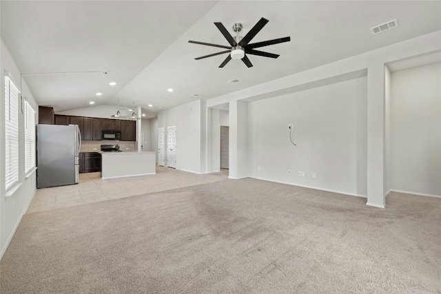 unfurnished living room featuring light colored carpet, lofted ceiling, and a healthy amount of sunlight