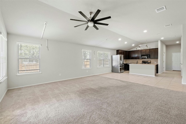 unfurnished living room featuring ceiling fan, vaulted ceiling, and light tile patterned floors