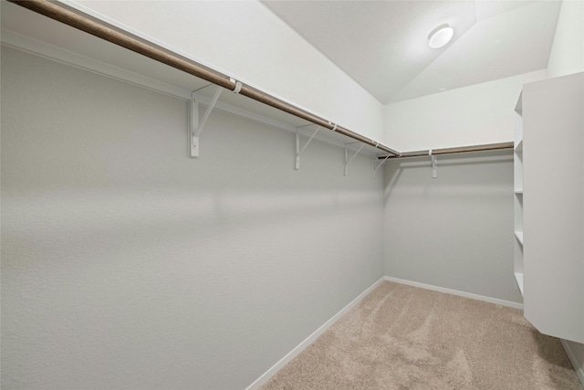 spacious closet featuring carpet floors and lofted ceiling