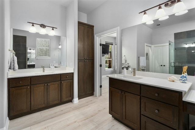 bathroom featuring hardwood / wood-style flooring, vanity, and a shower with shower door