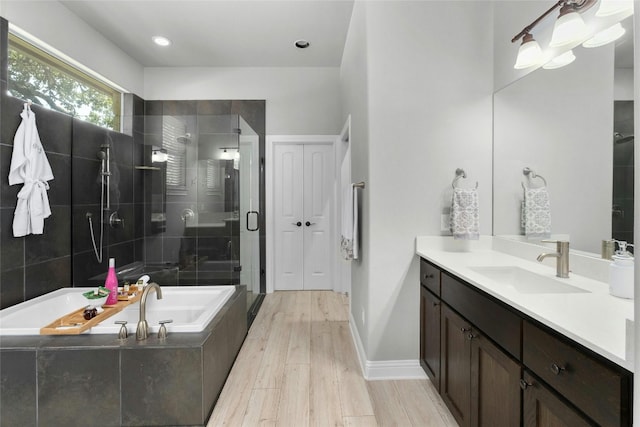 bathroom featuring separate shower and tub, hardwood / wood-style floors, and vanity