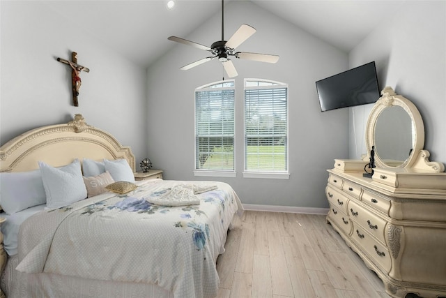 bedroom with ceiling fan, light wood-type flooring, and lofted ceiling