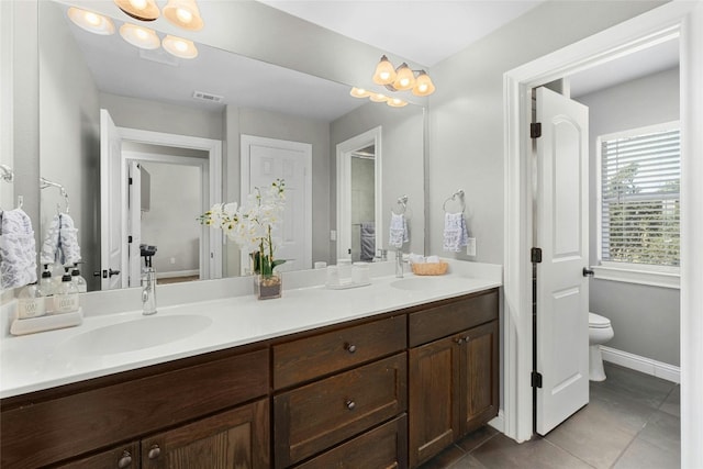 bathroom featuring tile patterned flooring, vanity, toilet, and an inviting chandelier