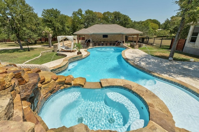 view of swimming pool featuring a yard, pool water feature, and a patio area