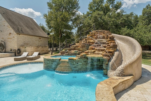 view of pool featuring an in ground hot tub and pool water feature