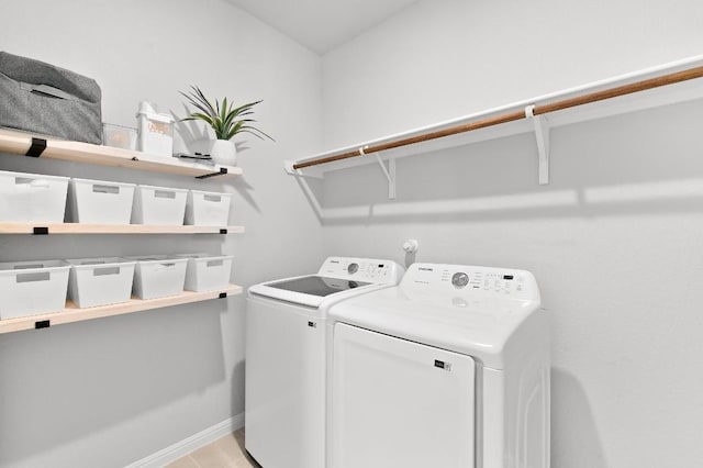 clothes washing area with washing machine and dryer and baseboards