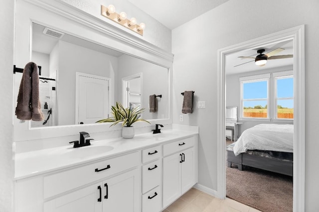 bathroom with double vanity, tile patterned flooring, a ceiling fan, ensuite bath, and baseboards