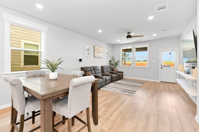 dining space with ceiling fan and light hardwood / wood-style flooring