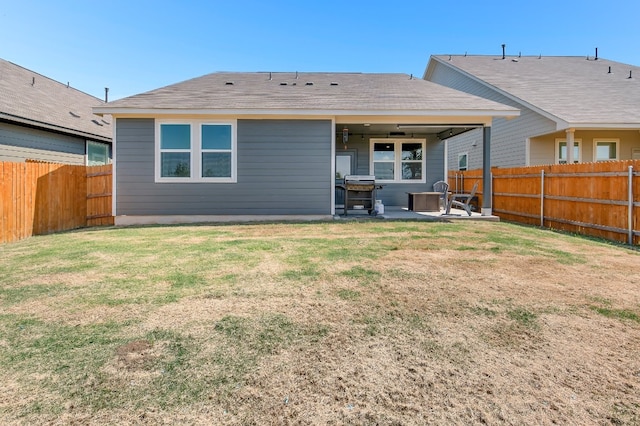 rear view of house featuring a patio area and a yard