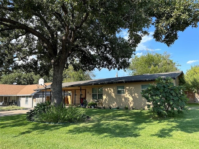 ranch-style house featuring brick siding and a front lawn