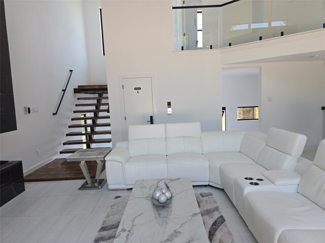 living room with light hardwood / wood-style flooring and a towering ceiling