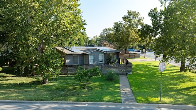 view of front of house with solar panels and a front lawn