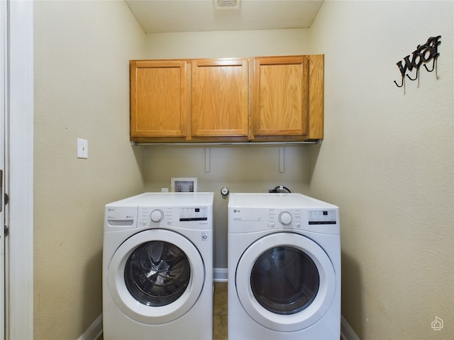 laundry room featuring cabinets and washing machine and clothes dryer