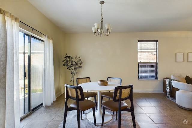 dining area with light tile patterned flooring, a wealth of natural light, and a chandelier