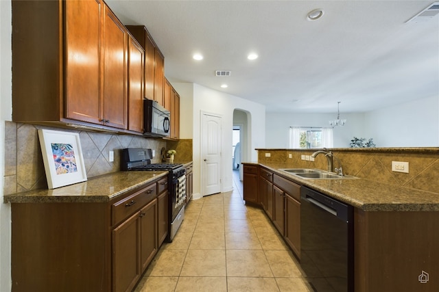 kitchen with appliances with stainless steel finishes, sink, pendant lighting, an inviting chandelier, and light tile patterned flooring