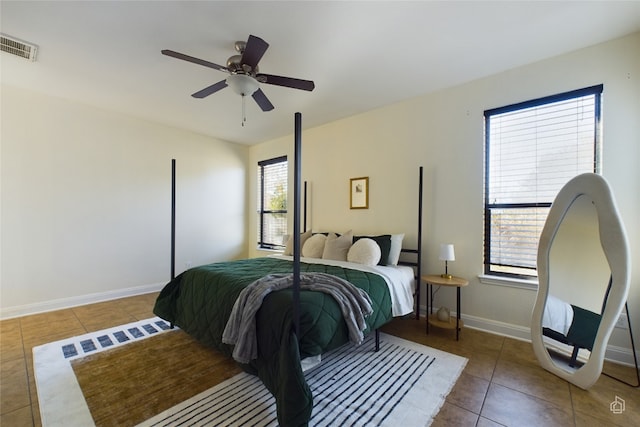 tiled bedroom featuring multiple windows and ceiling fan