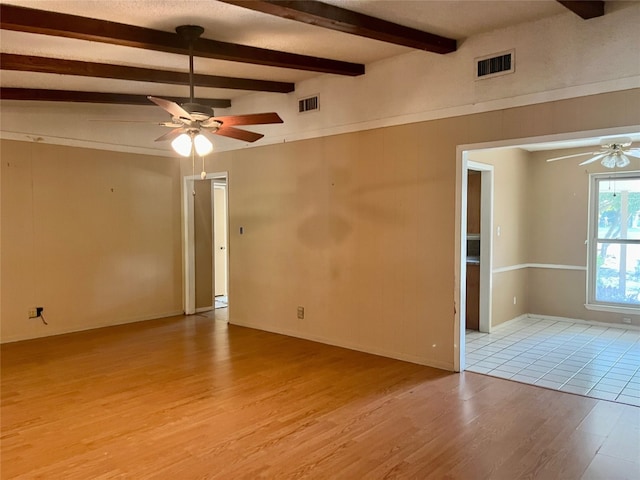 unfurnished room with light tile patterned flooring, vaulted ceiling with beams, and ceiling fan