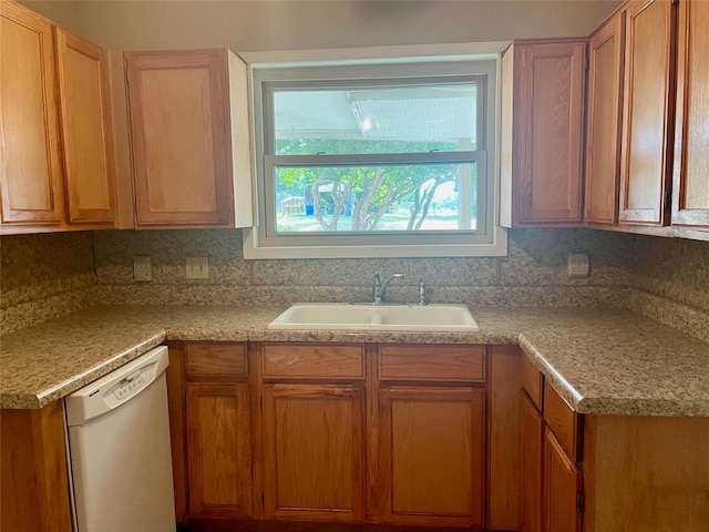 kitchen featuring sink, decorative backsplash, and white dishwasher