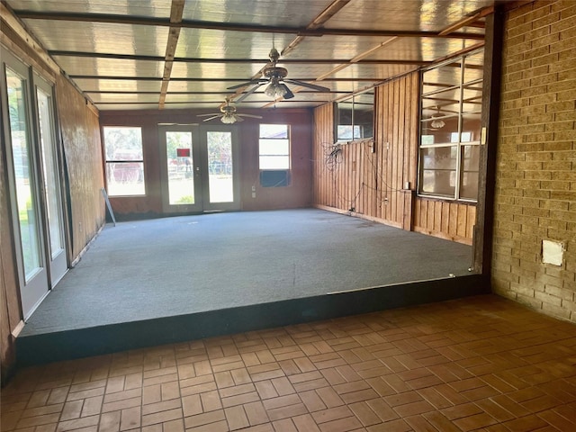 unfurnished sunroom featuring ceiling fan and french doors