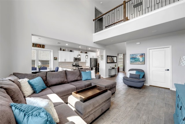 121 Woods Edge Ln, Georgetown, TX 78628 - living room featuring a towering ceiling, baseboards, light wood-style floors, and recessed lighting