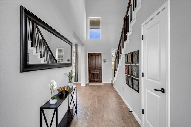 121 Woods Edge Ln, Georgetown, TX 78628 - doorway to outside featuring stairs, baseboards, wood finished floors, and a towering ceiling