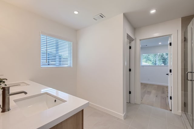 bathroom featuring hardwood / wood-style floors, vanity, and a shower with shower door