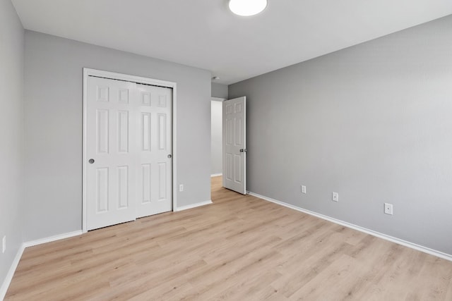 unfurnished bedroom featuring light wood-type flooring and a closet