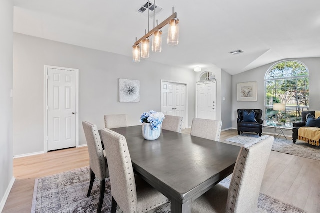 dining room featuring light hardwood / wood-style floors and lofted ceiling