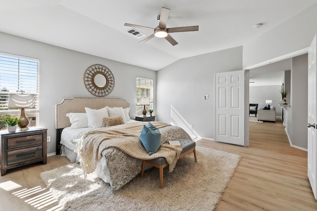 bedroom featuring multiple windows, vaulted ceiling, light hardwood / wood-style flooring, and ceiling fan