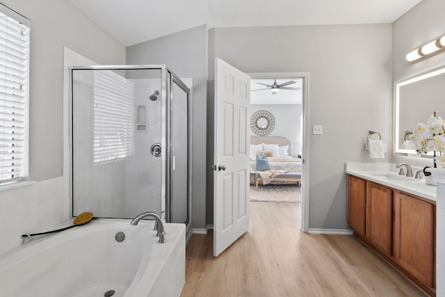 bathroom with hardwood / wood-style floors, independent shower and bath, vanity, and ceiling fan