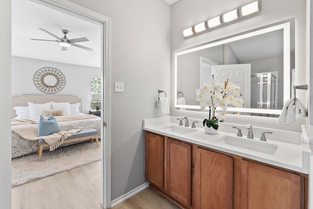 bathroom featuring hardwood / wood-style flooring, an enclosed shower, vanity, and ceiling fan