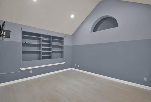 spare room with baseboards and wood finished floors