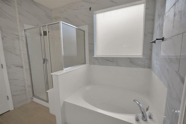 bathroom featuring a stall shower and a garden tub