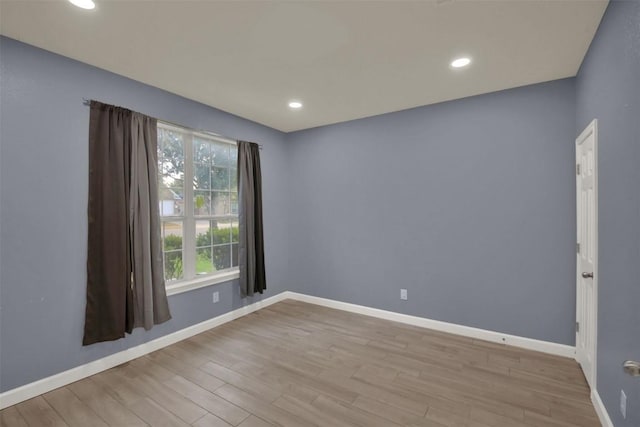 spare room featuring recessed lighting, light wood-style flooring, and baseboards