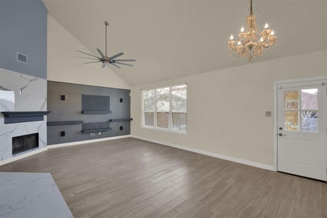 unfurnished living room featuring baseboards, a ceiling fan, wood finished floors, high vaulted ceiling, and a high end fireplace