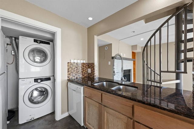 laundry area with sink and stacked washer / drying machine