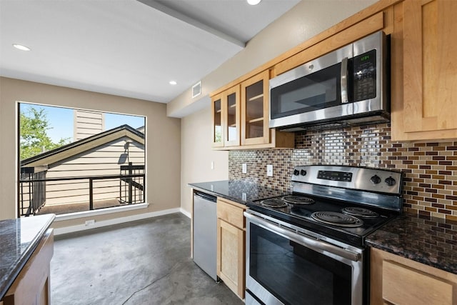 kitchen featuring appliances with stainless steel finishes, light brown cabinetry, backsplash, and dark stone counters