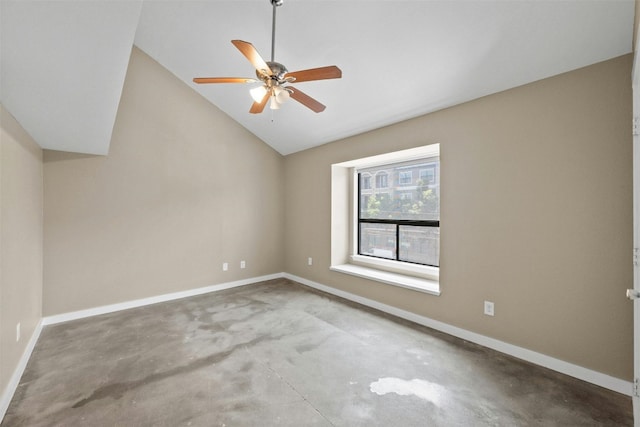 spare room with ceiling fan, concrete floors, and vaulted ceiling