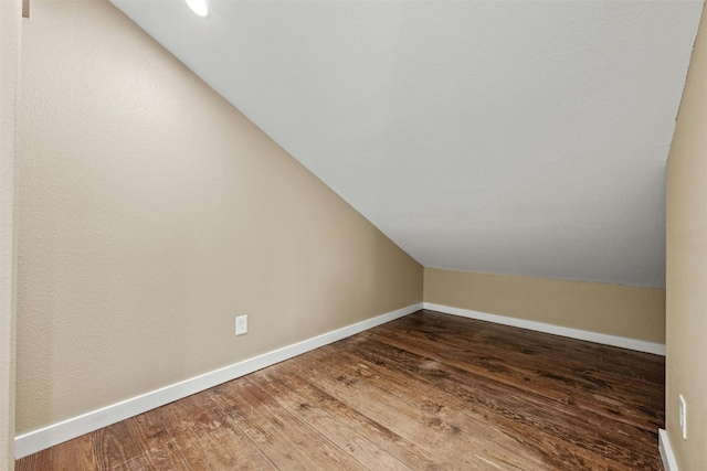 additional living space with vaulted ceiling and wood-type flooring