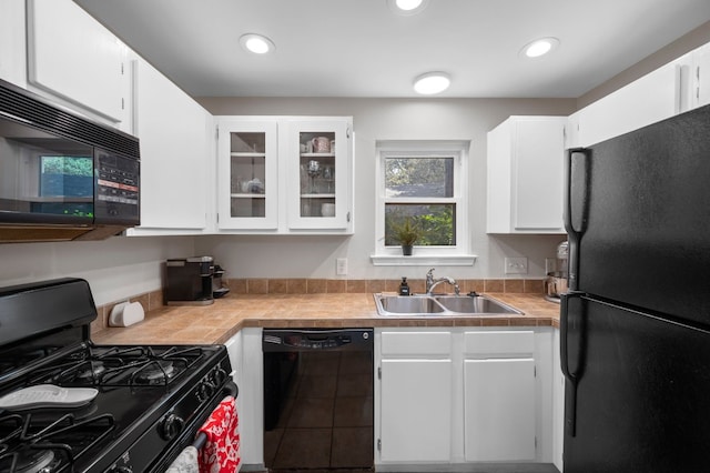 kitchen with sink, white cabinets, and black appliances