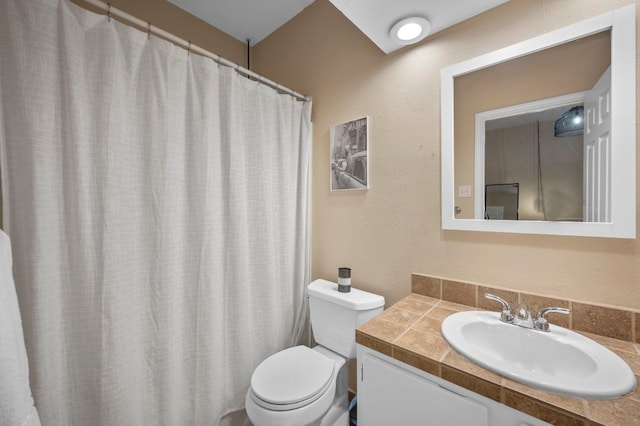 bathroom featuring toilet, vanity, and walk in shower