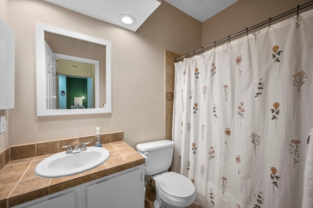 bathroom with toilet, vanity, and curtained shower