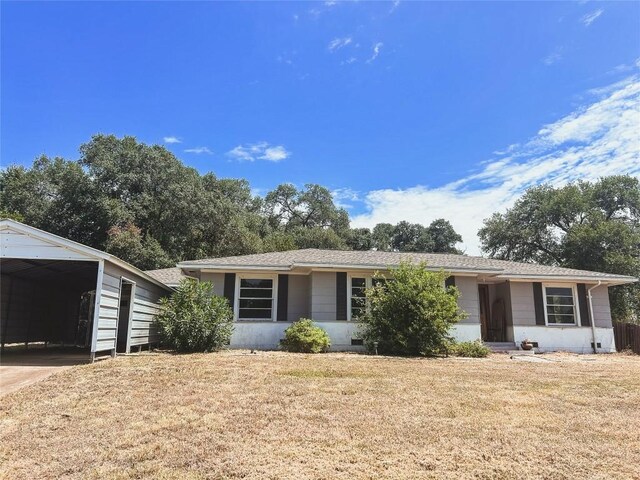 ranch-style house with a front yard and a carport