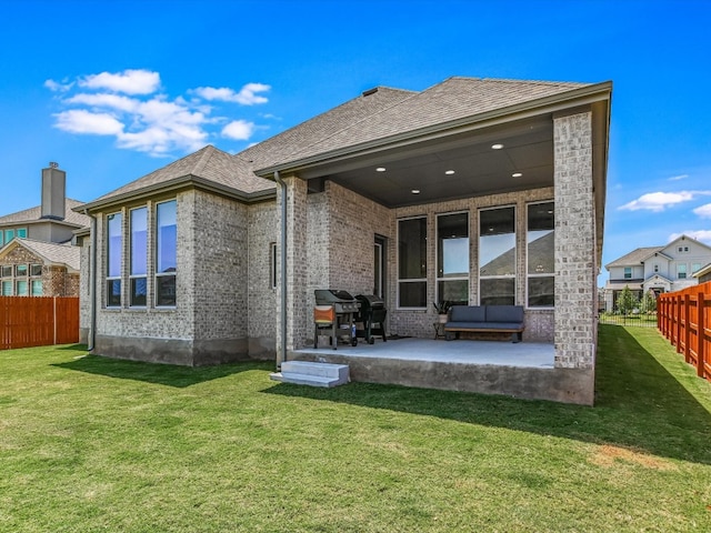 rear view of house with a lawn and a patio area