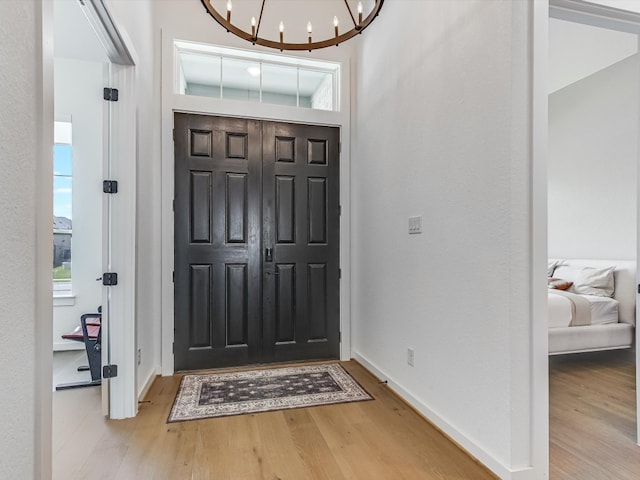 foyer featuring light hardwood / wood-style floors and a notable chandelier