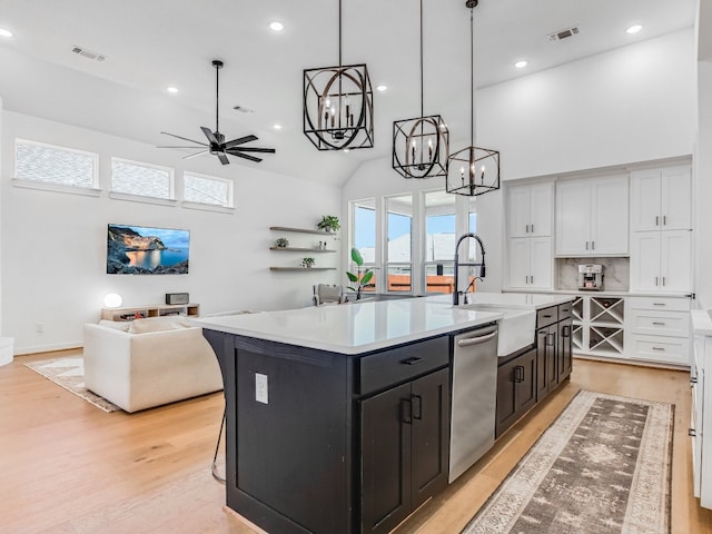 kitchen featuring a kitchen island with sink, dishwasher, white cabinets, and ceiling fan