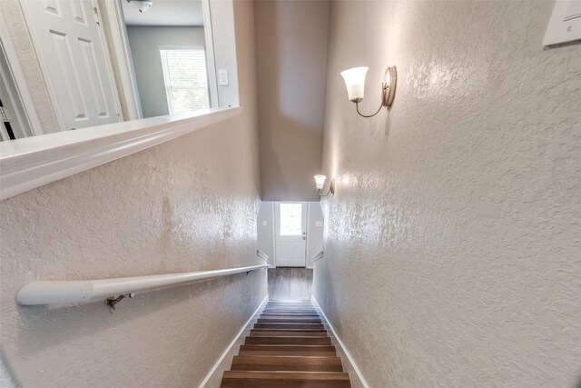 8236 Brucks Dr, San Antonio, TX 78244 - staircase featuring wood finished floors, a textured wall, and plenty of natural light