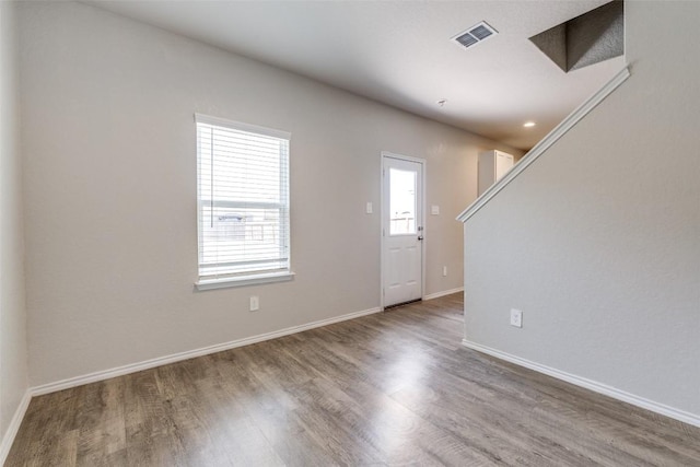 interior space featuring baseboards, visible vents, and wood finished floors